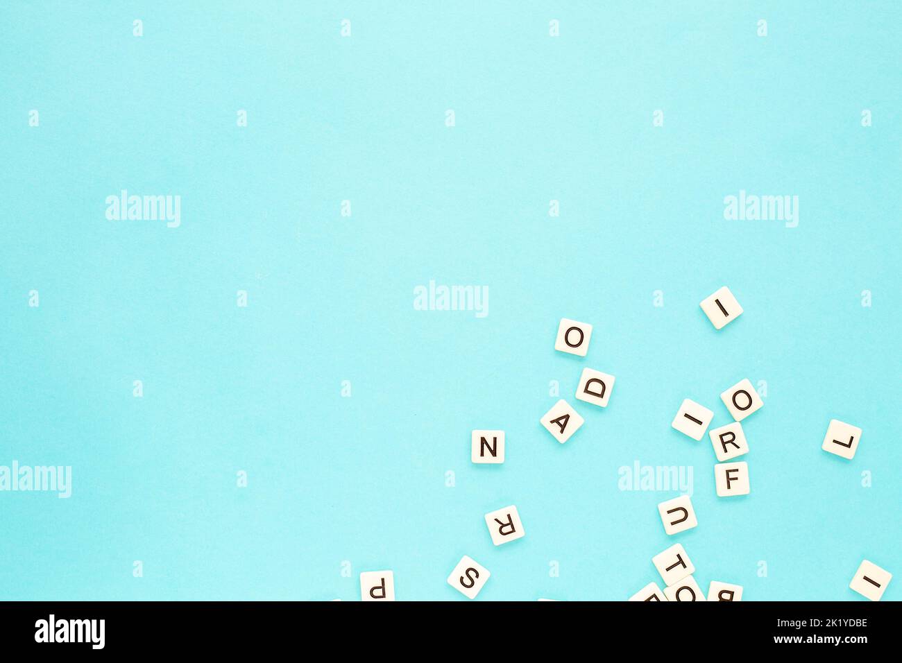 Zufällige Buchstaben auf blauem Hintergrund. Verstreutes englisches Alphabet. Speicherplatz kopieren. Abstrakter minimalistischer Hintergrund Stockfoto