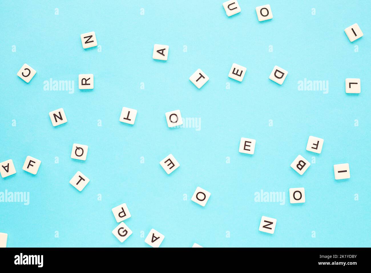 Zufällige Buchstaben auf blauem Hintergrund. Verstreutes englisches Alphabet. Abstrakter minimalistischer Hintergrund Stockfoto