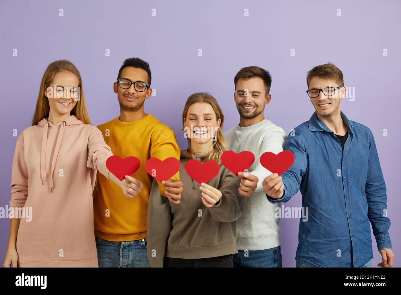 Lächelnde Menschen halten Papierherzen und zeigen Liebe Stockfoto