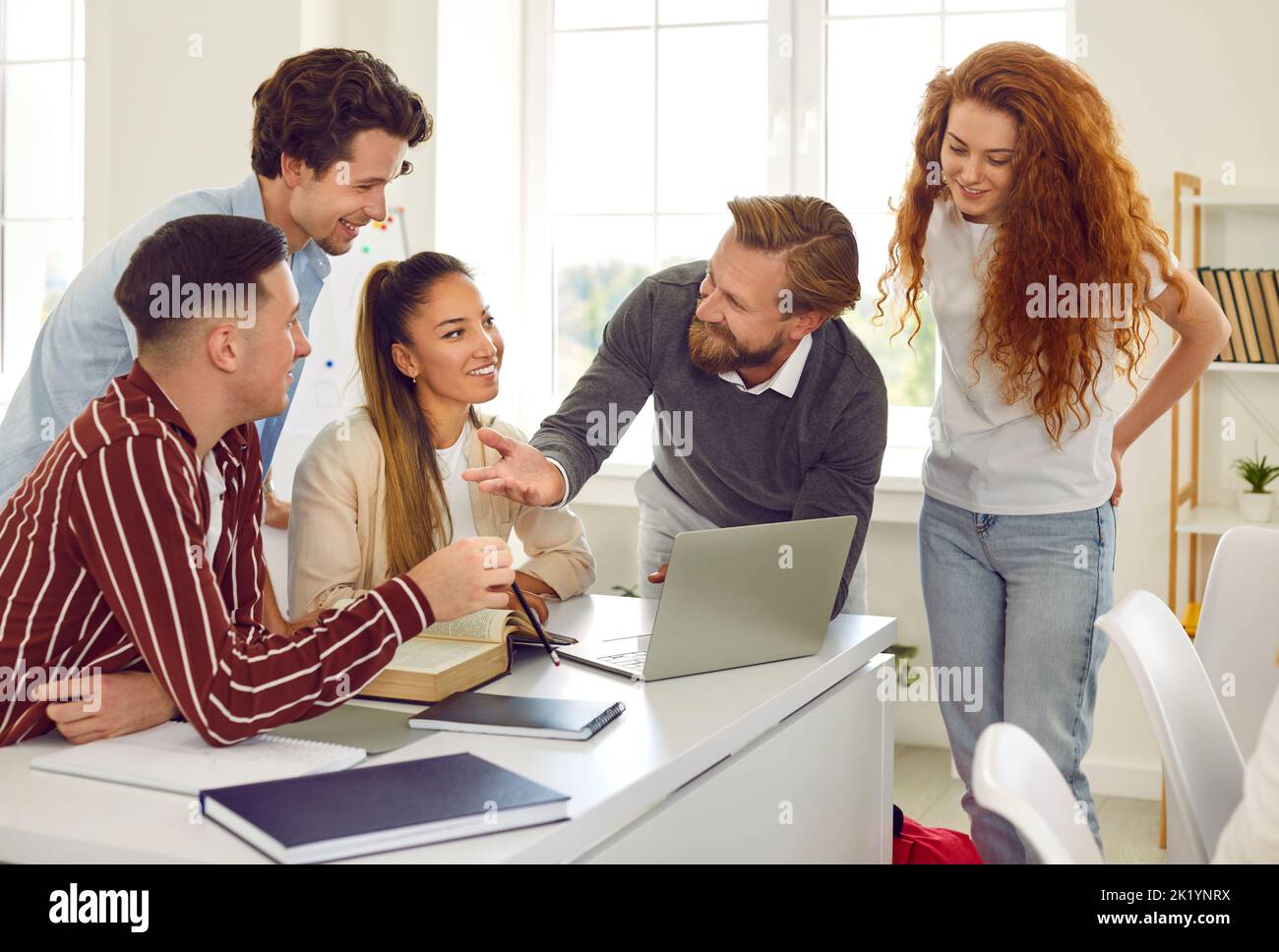 Der Lehrer sprach und benutzte einen Laptop in der Klasse, die mit seinen Teenagern an einem Projekt arbeitete. Stockfoto