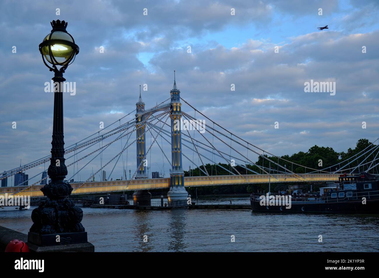 Blick auf die Albert Bridge von der Nordseite der Themse in London in der Abenddämmerung Stockfoto
