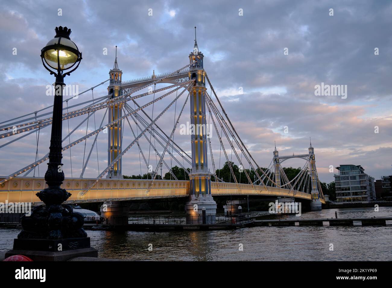 Blick auf die Albert Bridge von der Nordseite der Themse in London in der Abenddämmerung Stockfoto