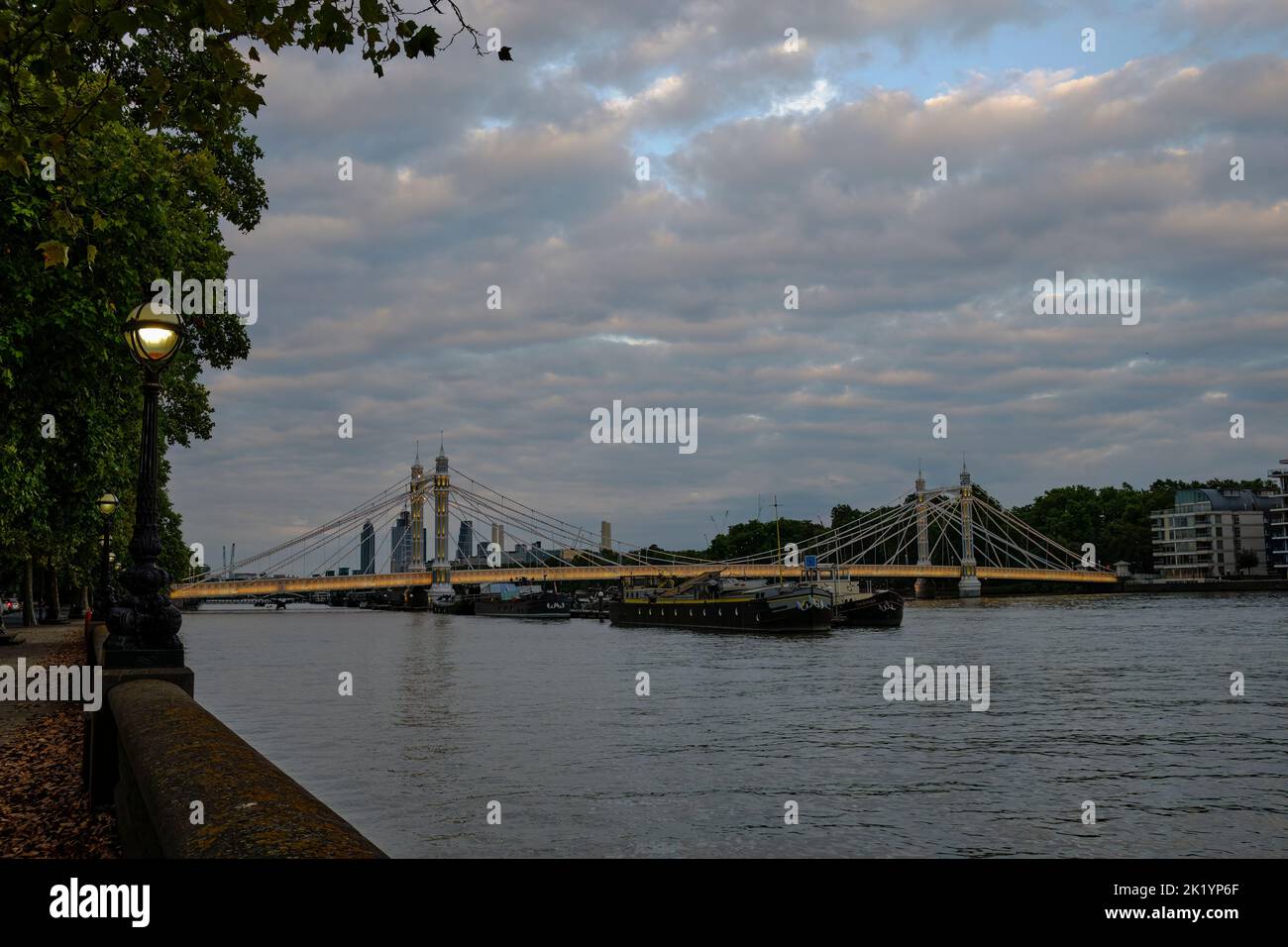 Blick auf die Albert Bridge von der Nordseite der Themse in London in der Abenddämmerung Stockfoto
