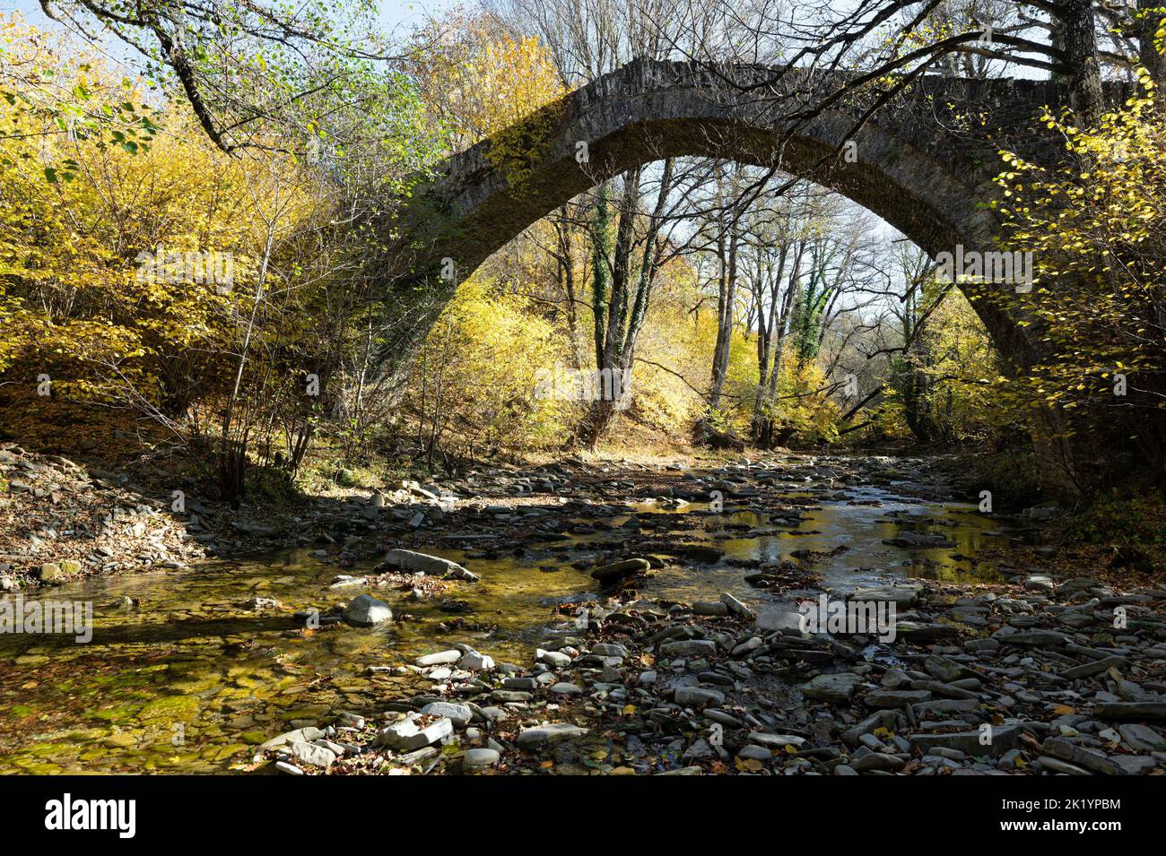 Blick auf die traditionelle steinerne Petsioni-Brücke in Epirus, Griechenland im Herbst Stockfoto