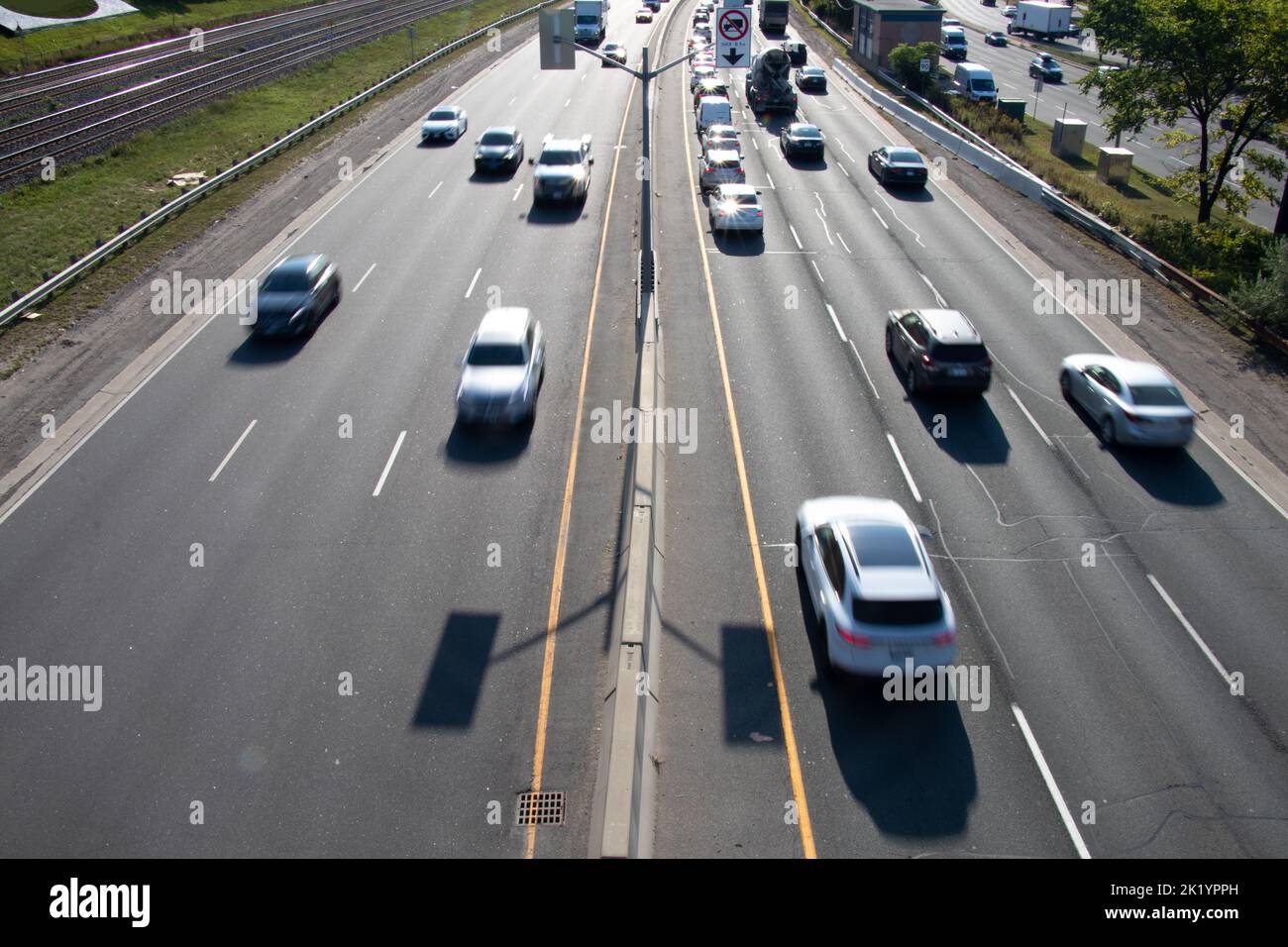 An einem sonnigen Morgen passiert unscharfer Verkehr auf einer belebten mehrspurigen Autobahn. Stockfoto