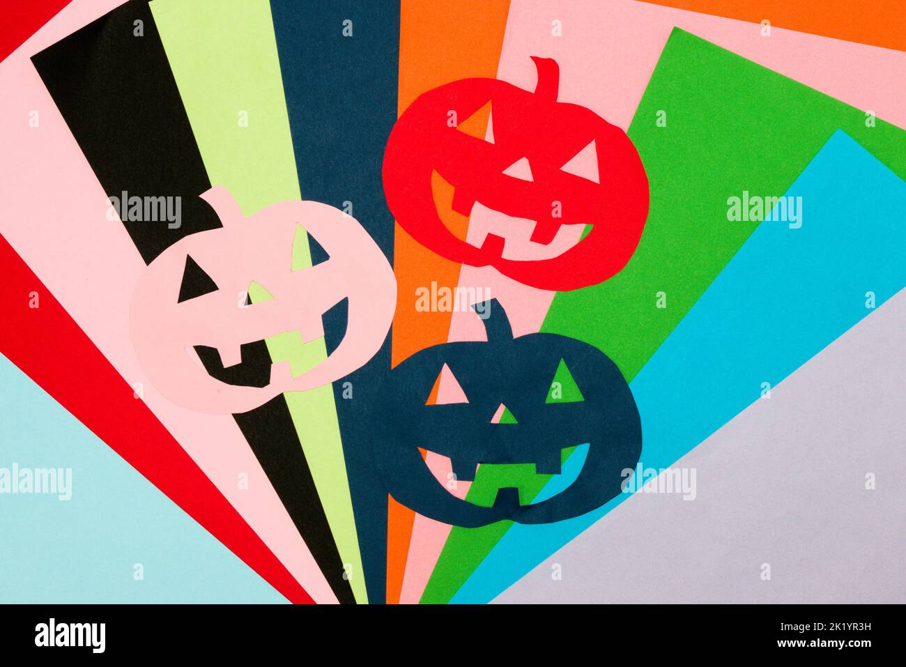 Bunte Kürbisse auf buntem Hintergrund, kreatives Kunstdesign, Halloween-Konzept Stockfoto