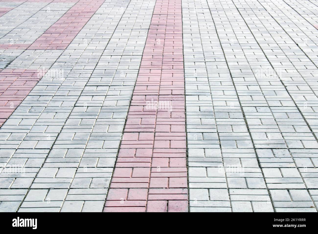 Weiße, graue, rote Fliesen auf dem Bürgersteig. Architektur, Bauwesen. Abstrakter lockiger Hintergrund. Stockfoto