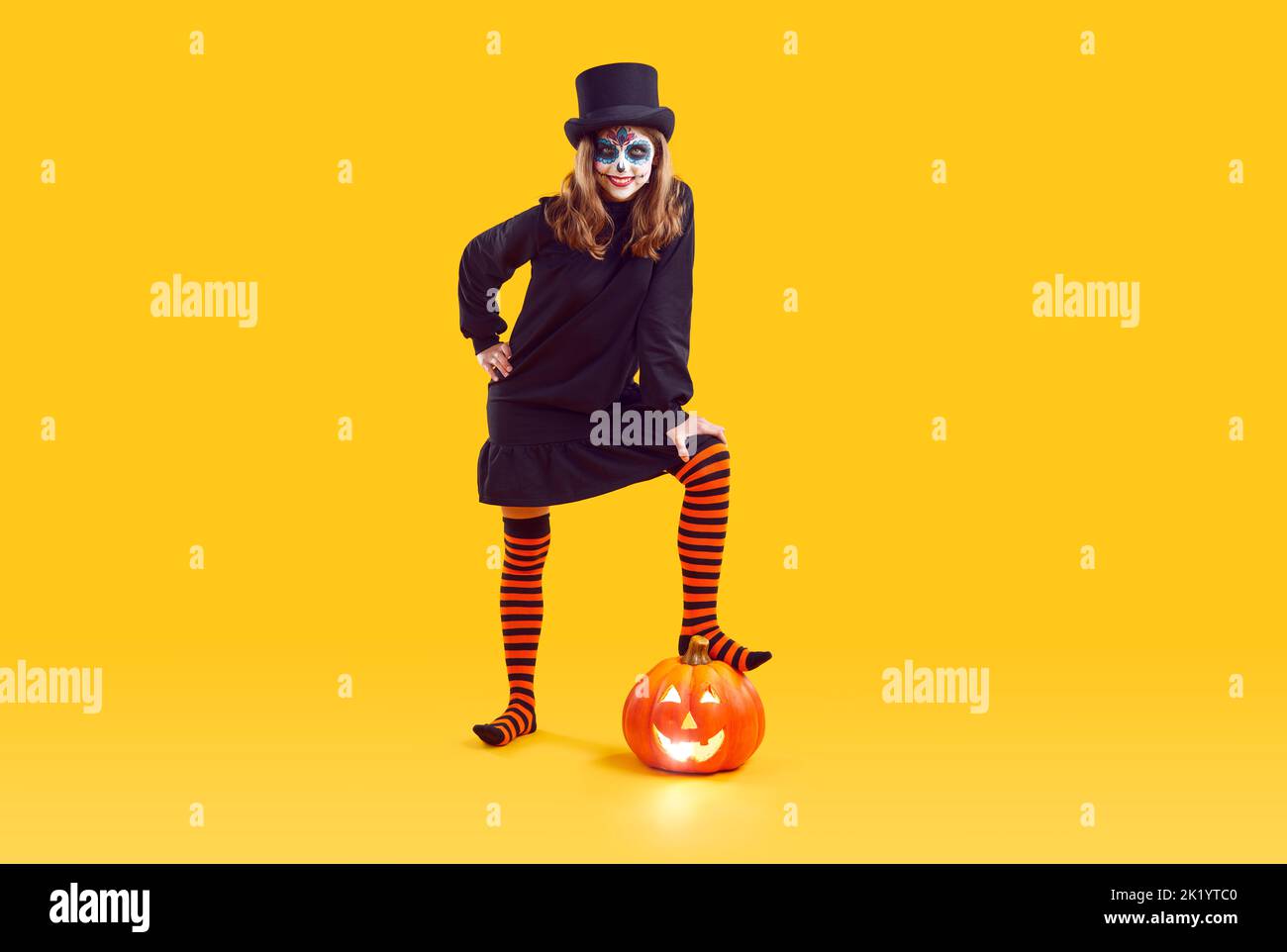 Porträt eines glücklichen Kindes in gruseligen Halloween Kostüm posiert auf gelbem Studiohintergrund Stockfoto
