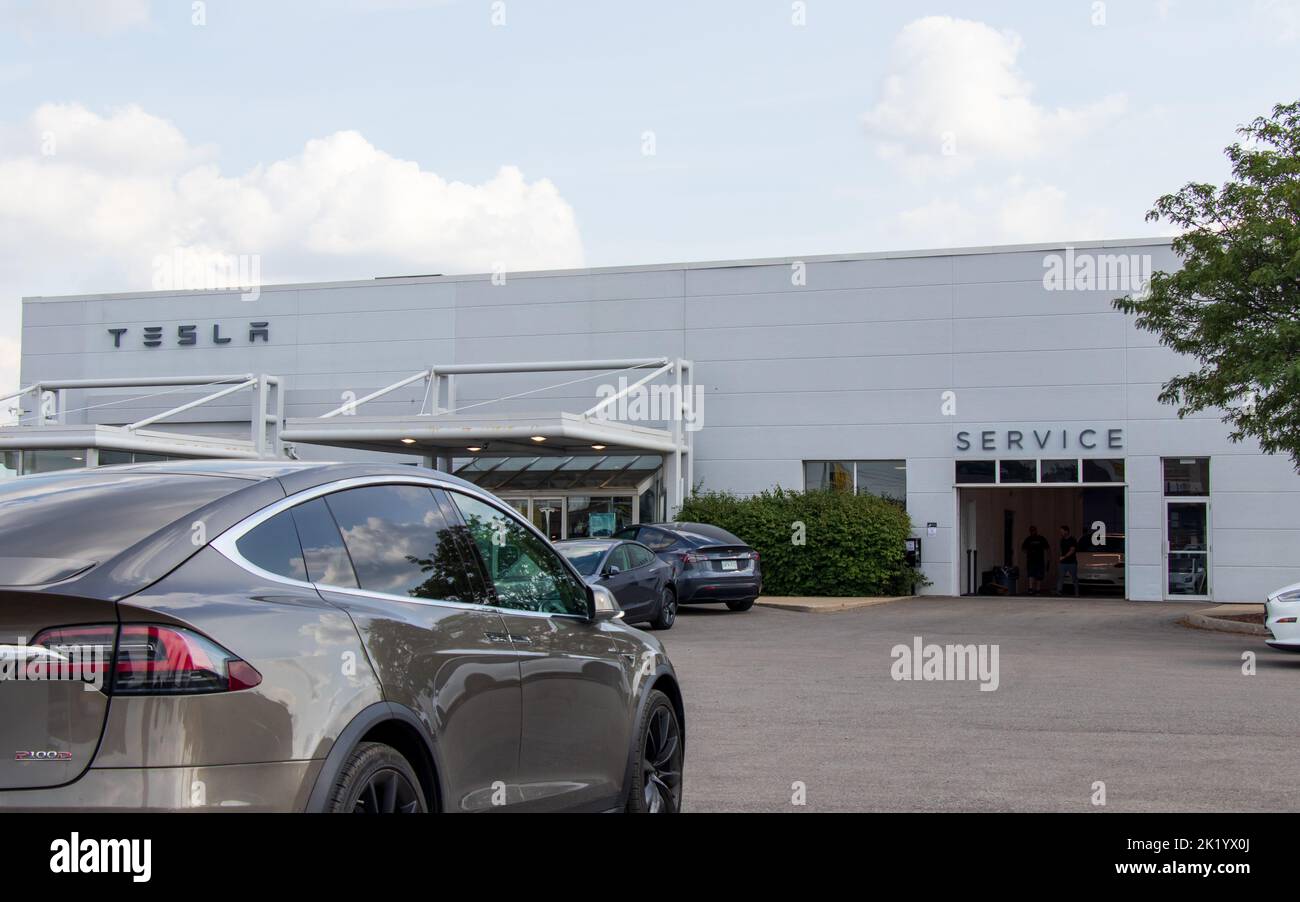 Ein Weitwinkelblick vor einem Tesla Händler mit einem goldenen Tesla Model X vor dem Hotel. Stockfoto Ein Weitwinkelblick vor einem Tesla Händler mit einem goldenen Tesla Model X vor dem Hotel. Stockfoto