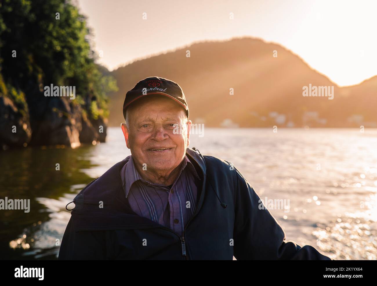 Porträt eines lächelnden älteren Mannes auf einem Boot bei Sonnenuntergang in Neufundland. Stockfoto