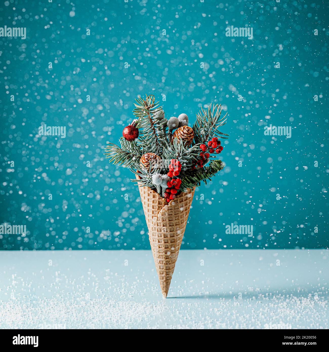 Weihnachts-Eiskegel im Schnee auf blauem Hintergrund. Neujahr Stockfoto