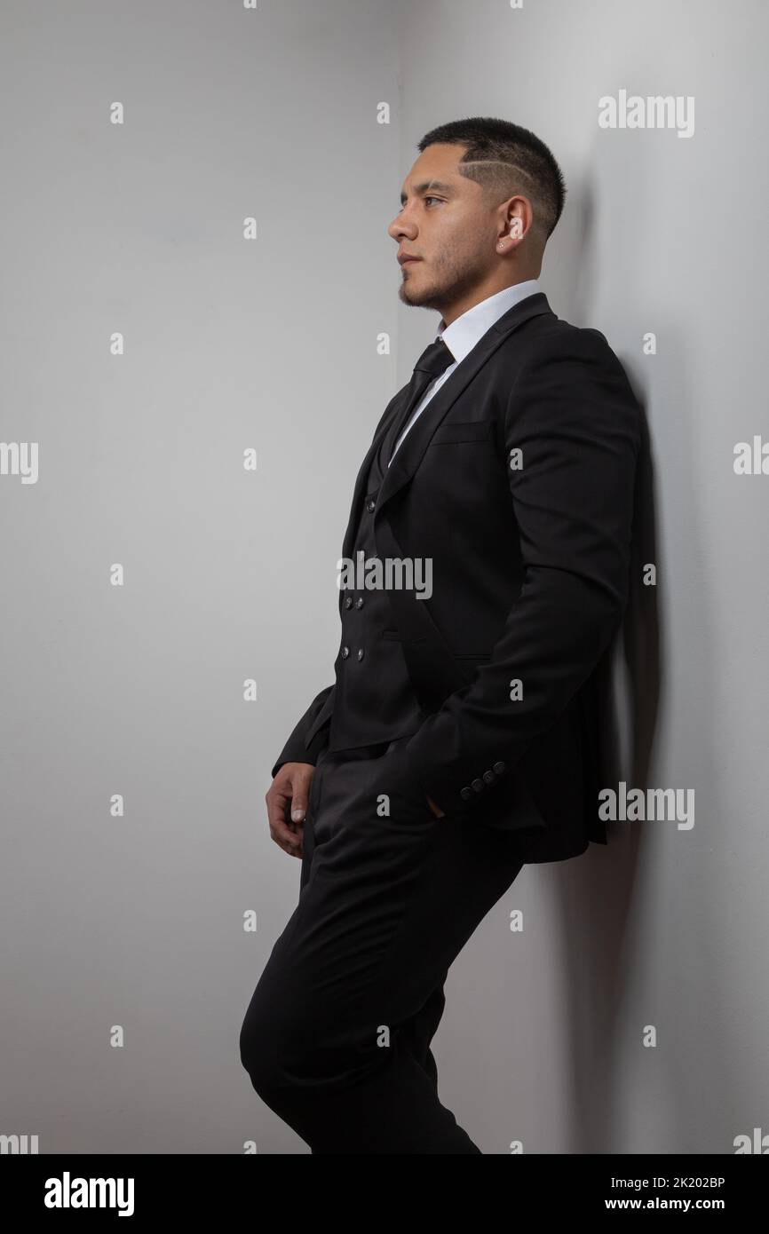Ein junger latein mit kurzen Haaren, Geschäftsreisenden und Lifestyle, elegant in einem Anzug mit Hemd und Krawatte, Stockfoto