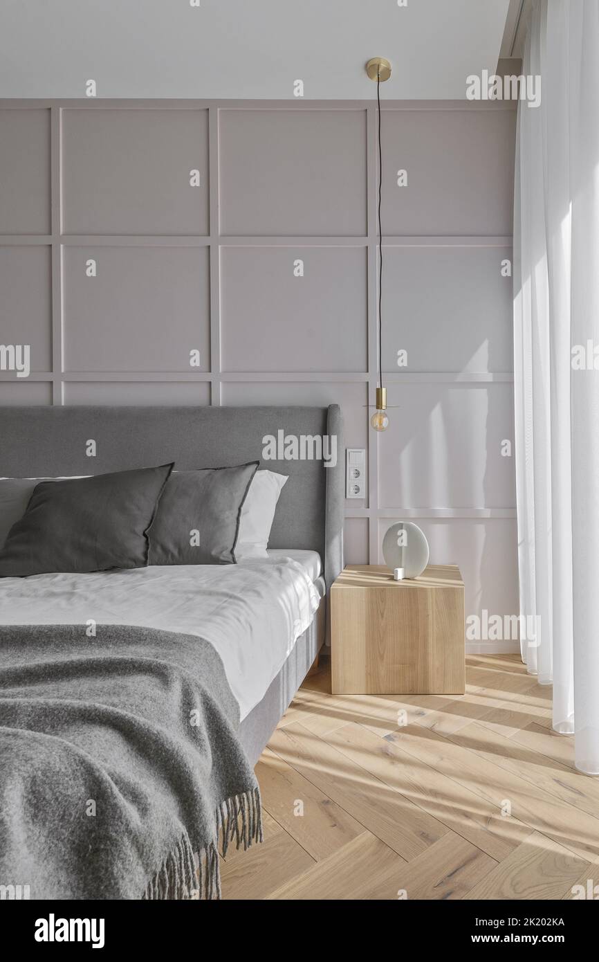 Moderne, minimalistische Einrichtung im Schlafzimmer mit grauen Möbeln und Eichenfußboden im skandinavischen Stil. Ästhetisch einfaches Innenraumkonzept. Stockfoto