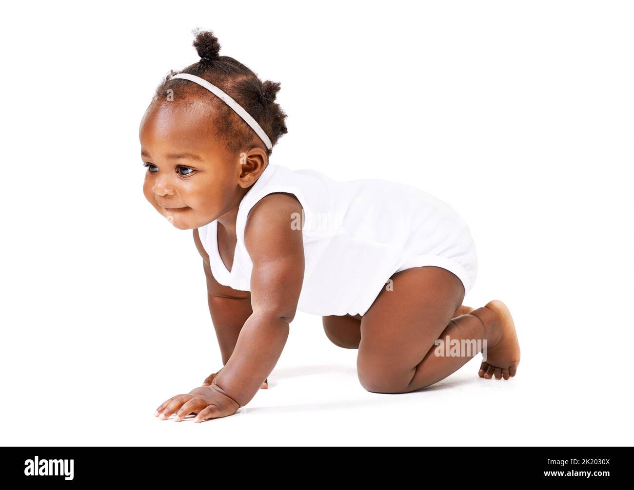 Zeit für ein Abenteuer. Studioaufnahme eines kleinen Mädchens, das vor einem weißen Hintergrund kriecht. Stockfoto