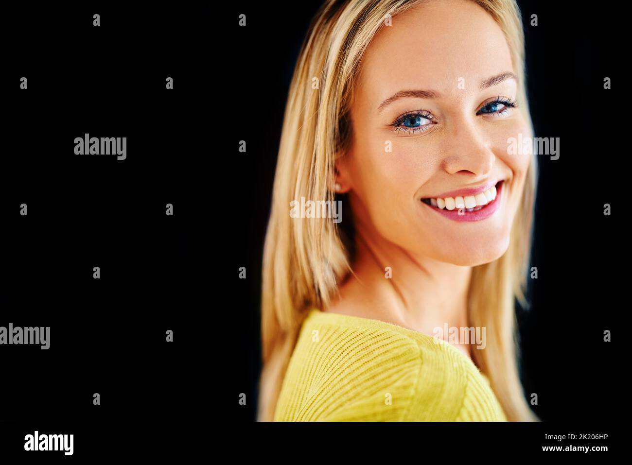 Kreieren Sie Ihren eigenen Sonnenschein. Studioportrait einer schönen jungen blonden Frau, isoliert auf Schwarz. Stockfoto