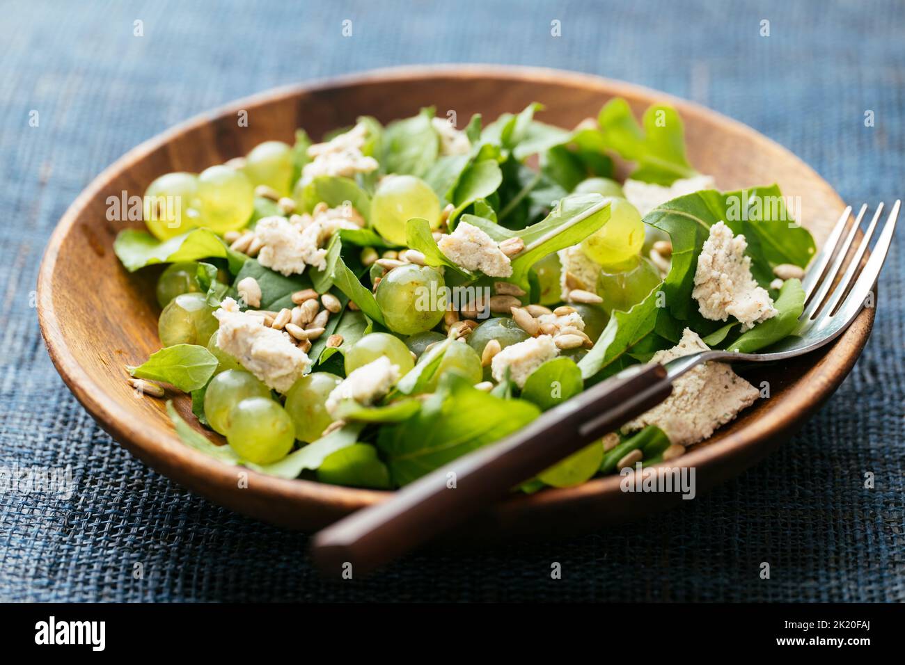 Hausgemachten Salat mit Rucola, Trauben, veganem Feta-Käse und Sonnenblumenkernen Stockfoto