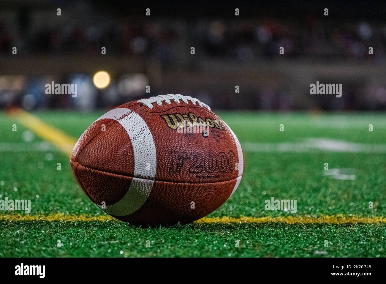 Nahaufnahme eines Wilson Fußballs auf Kunstrasen während eines Nachtfußballspiels. Stockfoto