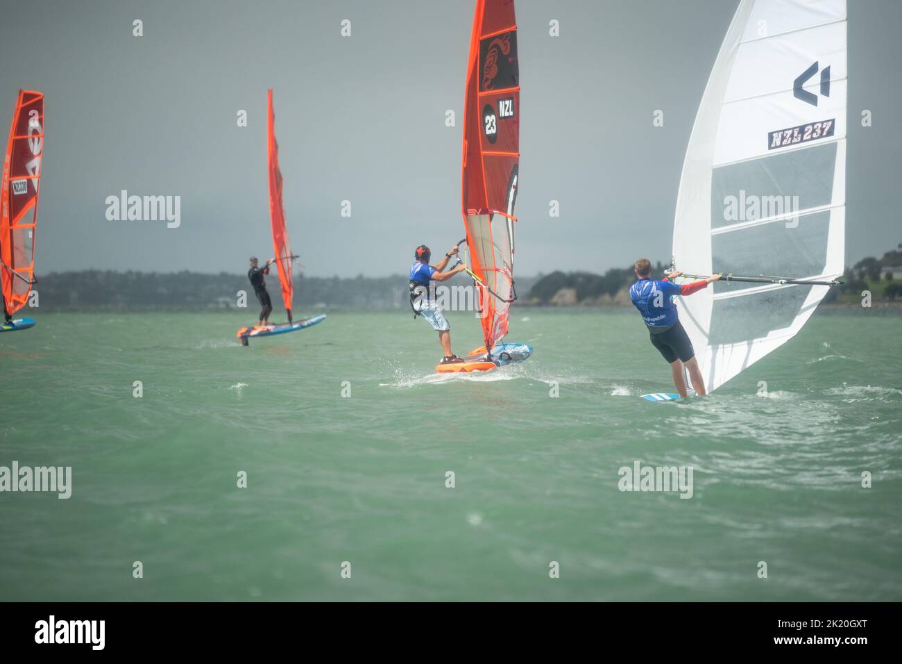 Teilnehmer des Waterbourne Watersports Festival, Takapuna Beach, Auckland, Neuseeland, nehmen an einem nationalen Windsurf-Tragflächenboot-Rennen Teil. Stockfoto