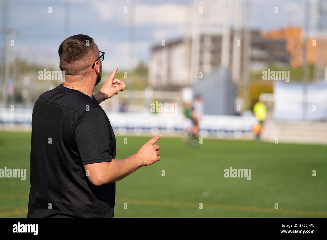 Fußballtrainer, der das Spiel vom Rand des Feldes aus steuert Stockfoto