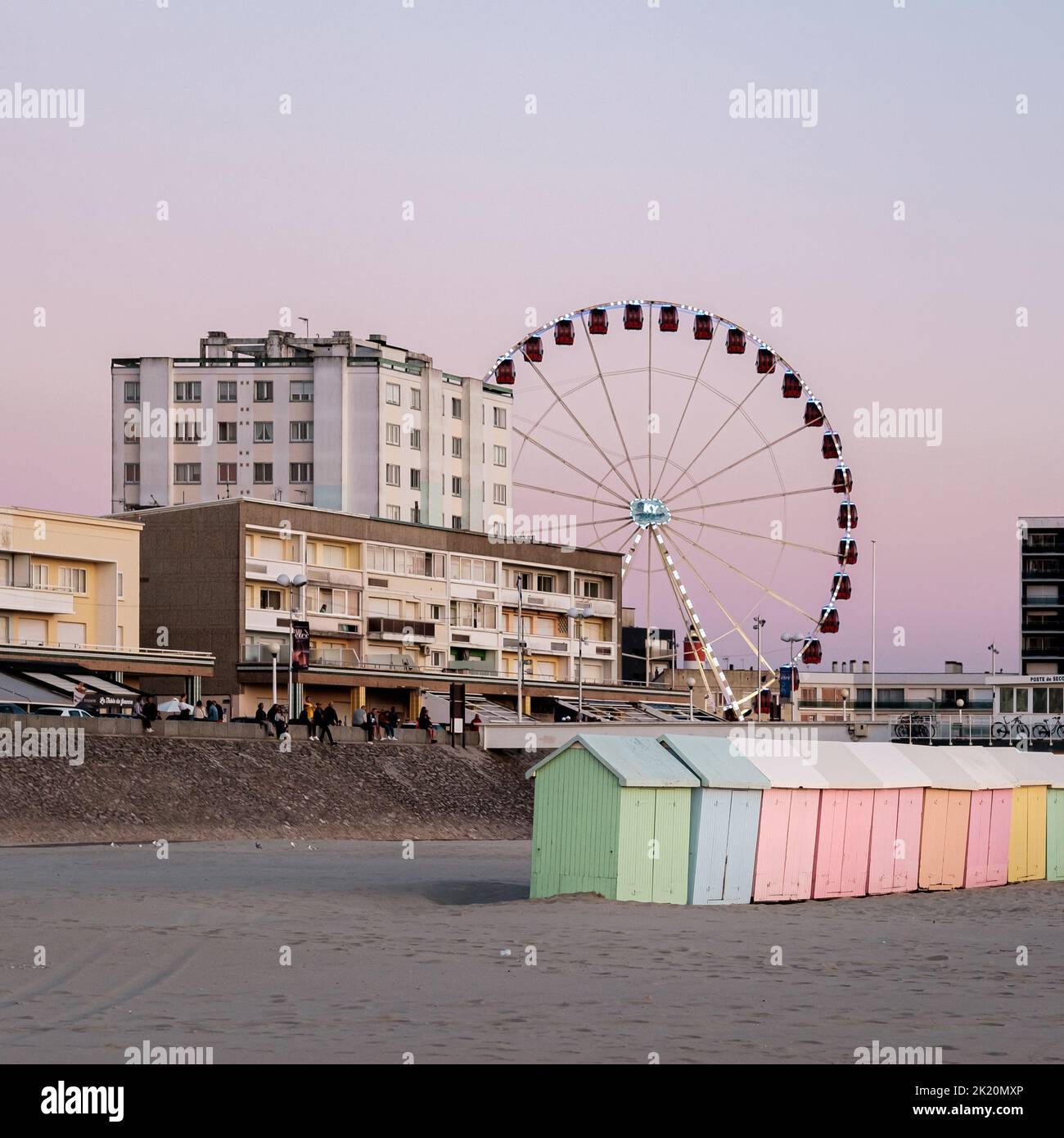 Pastellfarbene Strandhütten und Riesenrad am Strand Von Berck in Frankreich Stockfoto