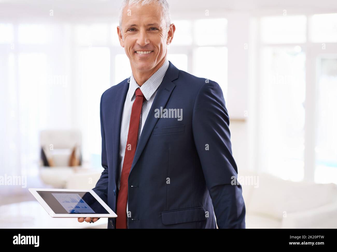 Unterwegs arbeiten. Ein reifer Geschäftsmann mit einem Tablet. Stockfoto