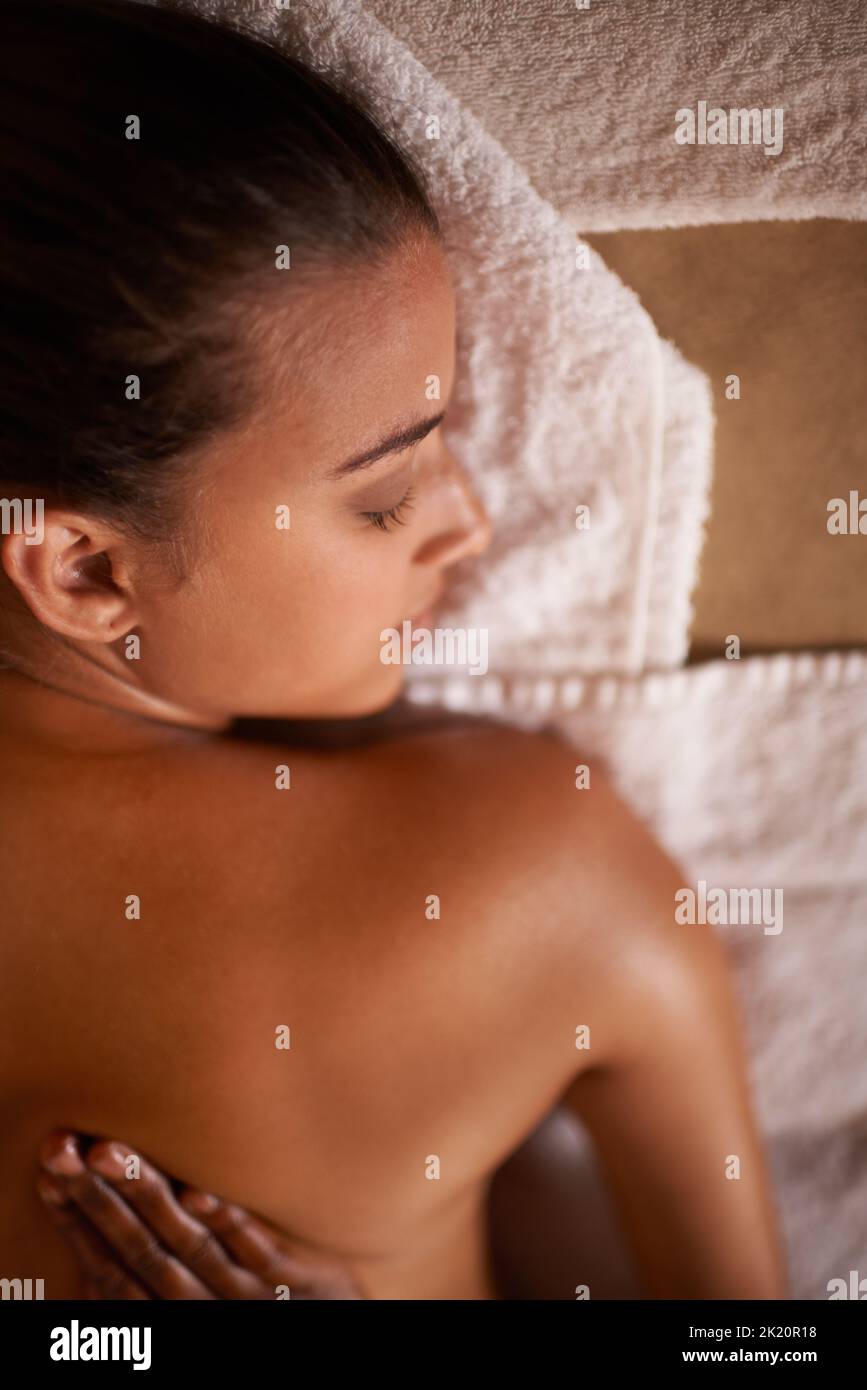 Im Zweifelsfall massieren Sie es aus ... eine junge Frau genießt eine entspannende Massage im Day Spa. Stockfoto