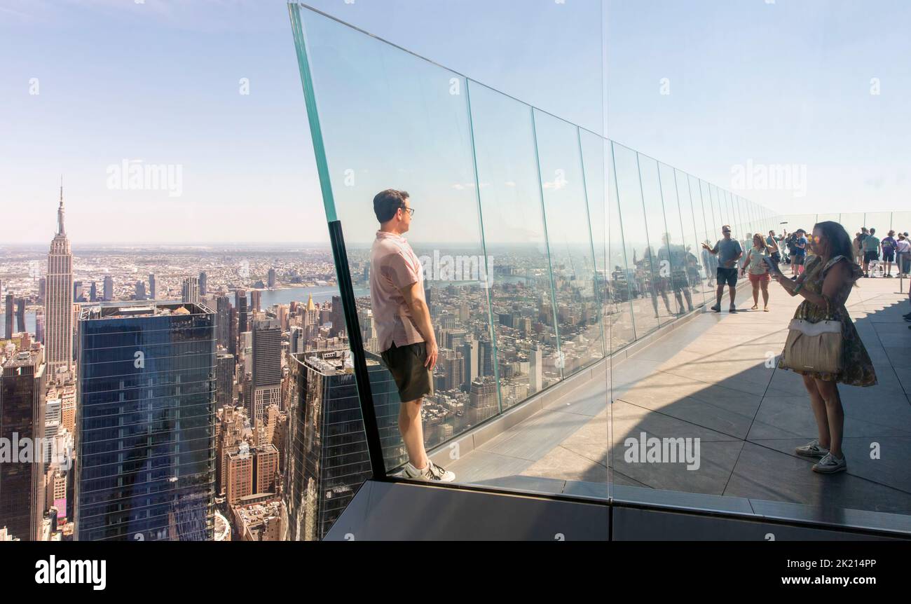 Eine Frau macht ein Smartphone-Foto von einem Mann auf dem Aussichtsterrasse Edge in Hudson Yards, Manhattan, NYC, USA Stockfoto