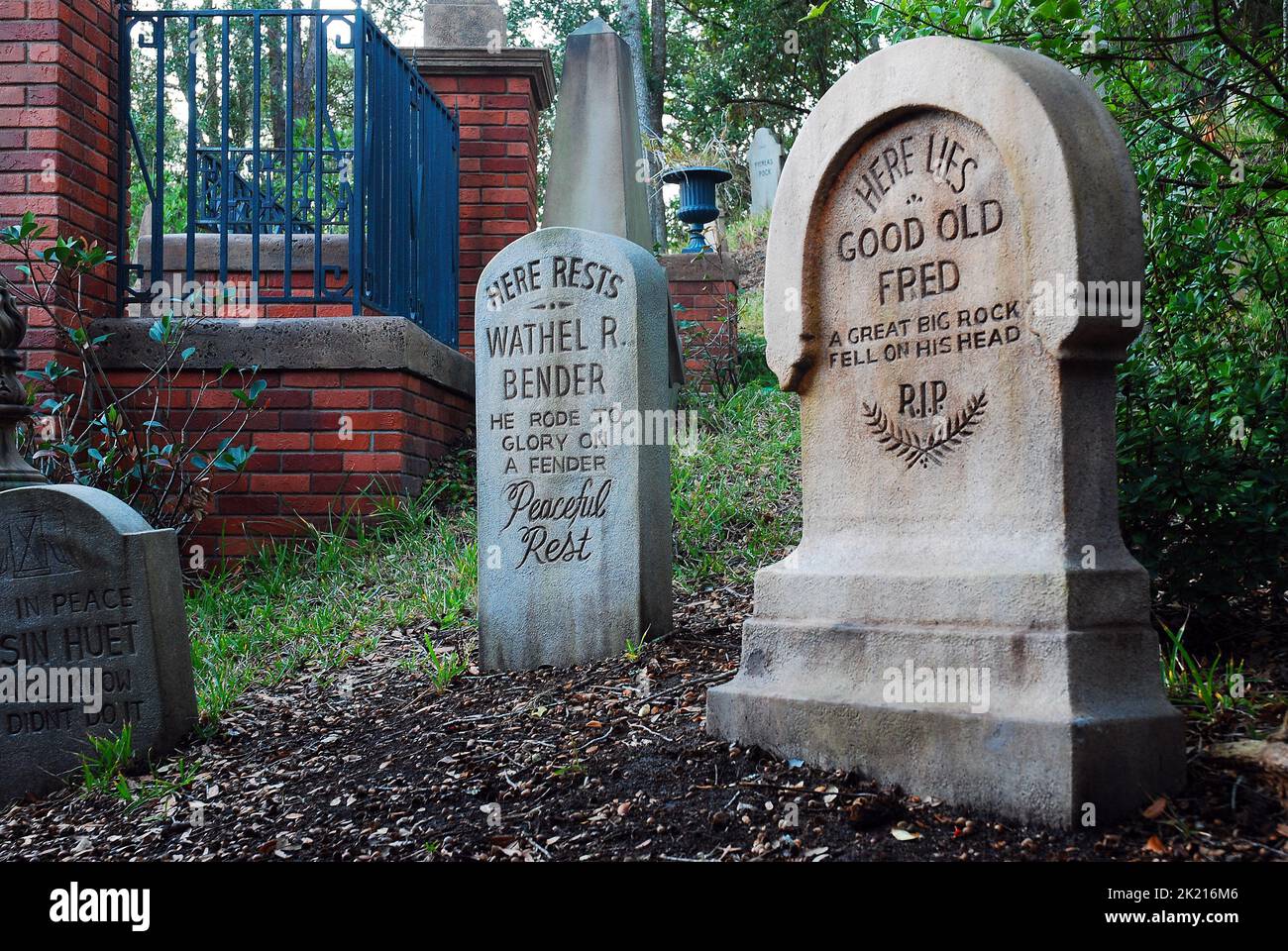 Die Grabsteine und Gräber auf dem gefälschten Friedhof außerhalb der Disney World Haunted Mansion Attraction erzählen Witze und humorvolle Geschichten Stockfoto