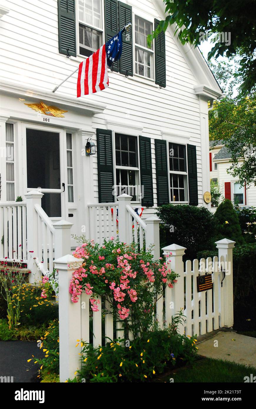 Am 4. Juli fliegt in Bristol, Rhode Island, eine amerikanische Flagge auf ein patriotisches Haus Stockfoto