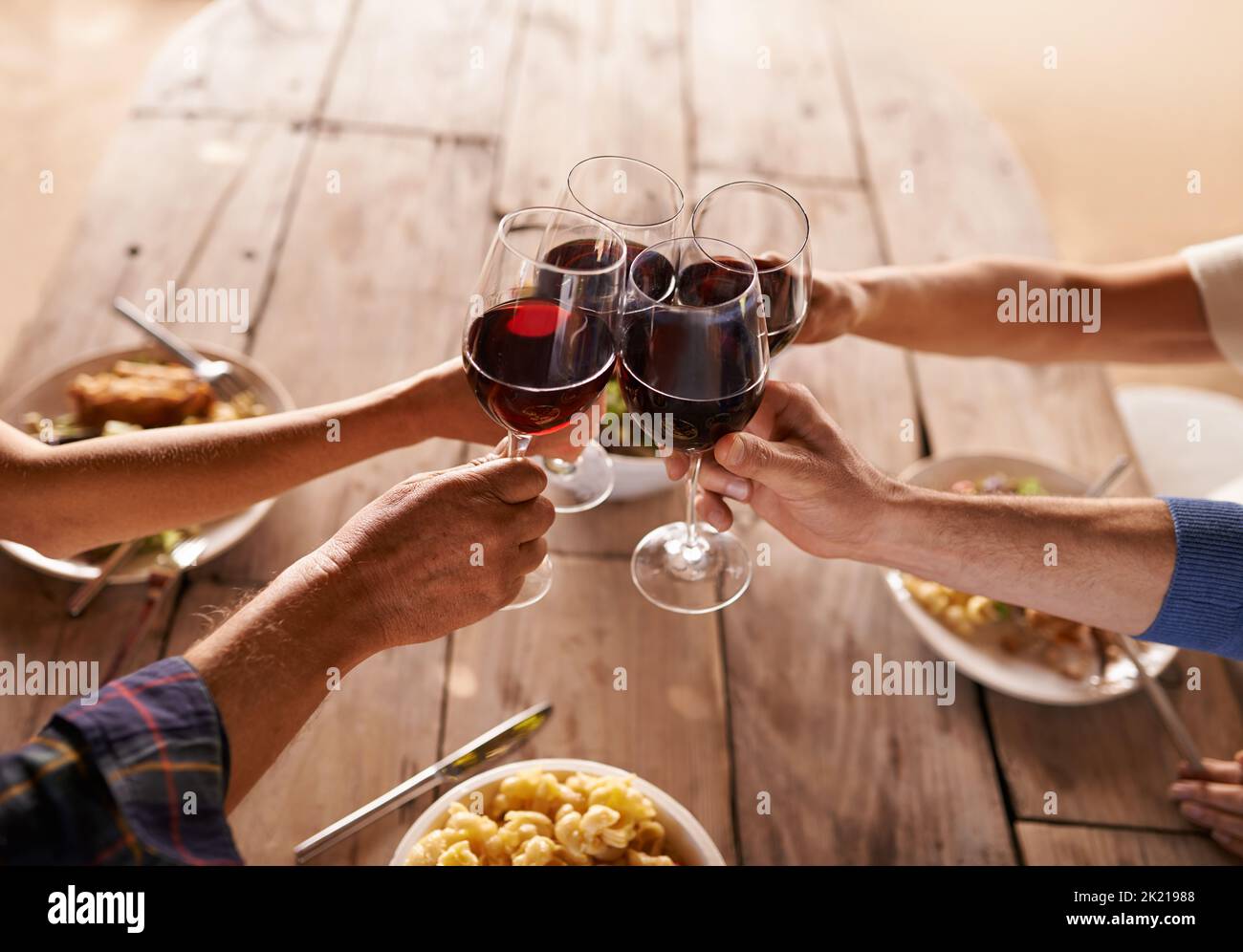 Heres zu guten Zeiten mit tollen Menschen. Menschen toasten mit Wein bei einer Mahlzeit. Stockfoto Heres zu guten Zeiten mit tollen Menschen. Menschen toasten mit Wein bei einer Mahlzeit. Stockfoto
