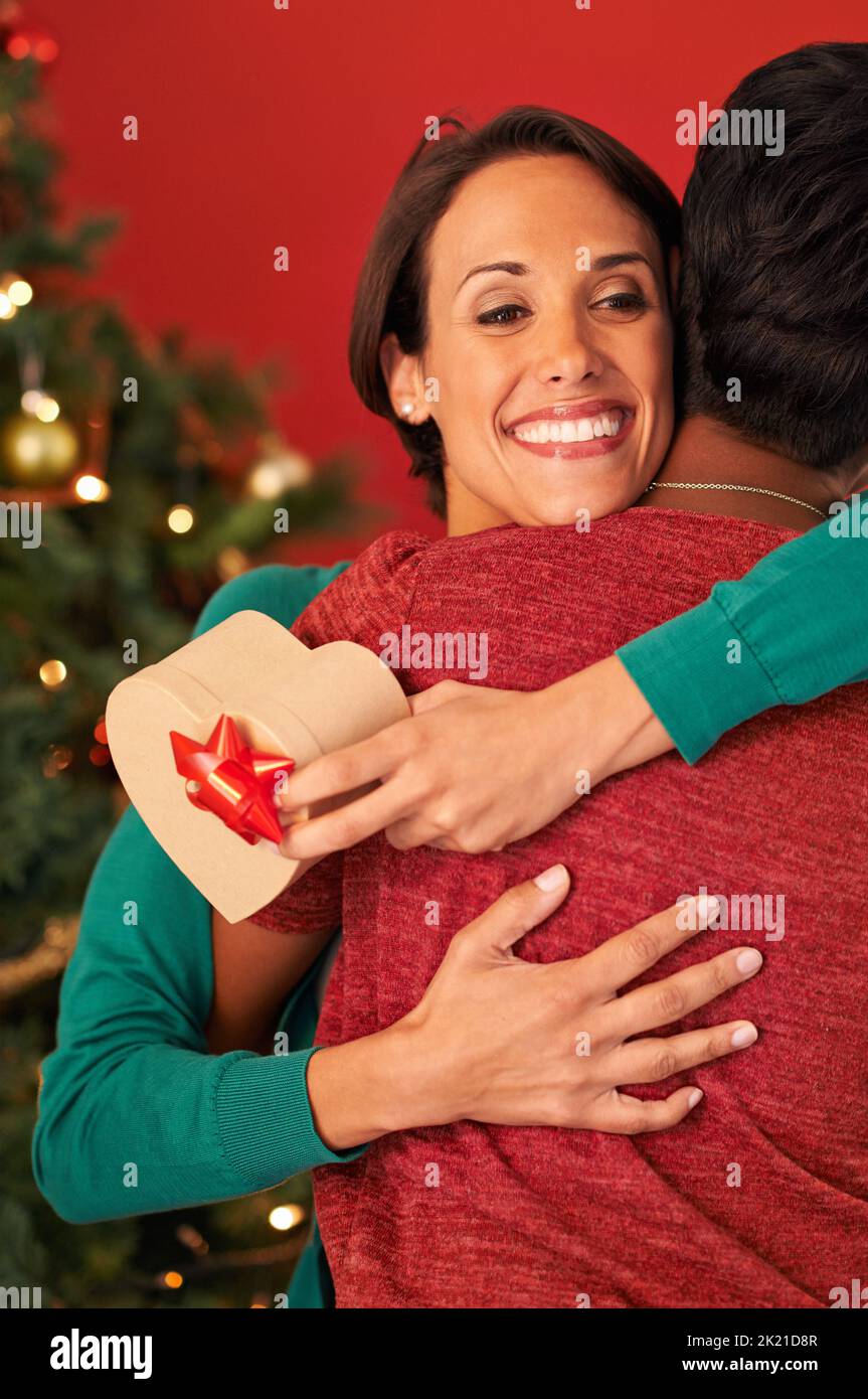 Vielen Dank. Eine junge Frau umarmte ihre Freundin, nachdem sie ein Weihnachtsgeschenk von ihr erhalten hatte. Stockfoto