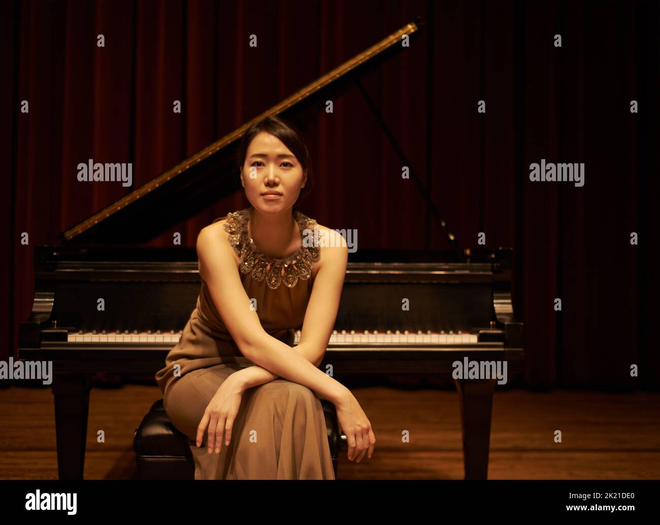Shes bekam das Selbstvertrauen zu spielen. Eine junge Frau, die am Ende eines musikalischen Konzerts an ihrem Klavier saß. Stockfoto