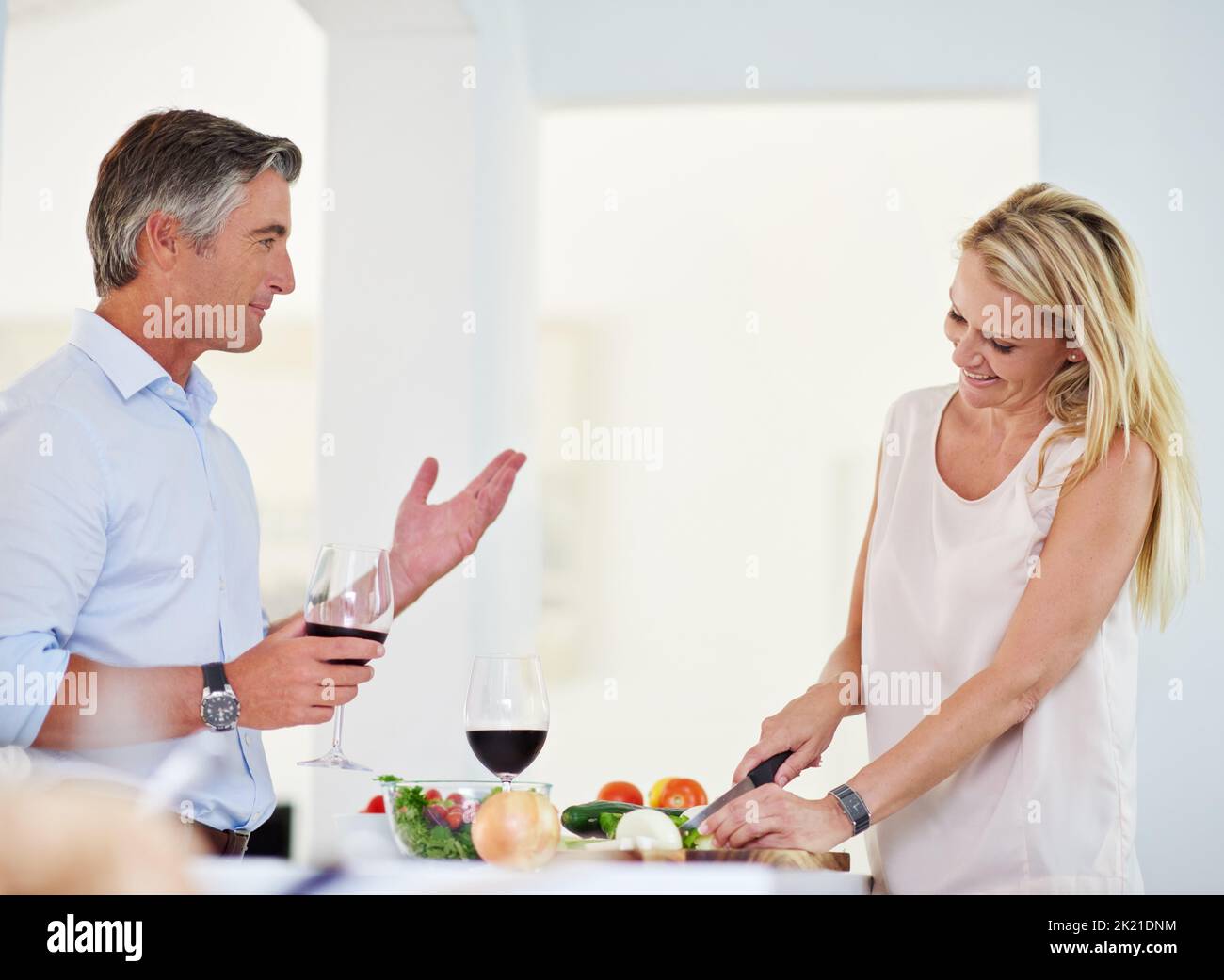Dinnertime Geplänkel. Ein reifes Paar, das beim Abendessen miteinander redet. Stockfoto