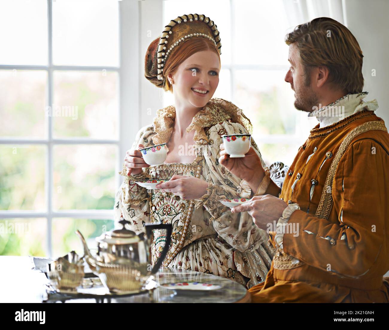 Ah, Tee... das Kennzeichen des zivilisierten. Ein König und eine Königin, die zu Hause gemeinsam Tee trinken. Stockfoto