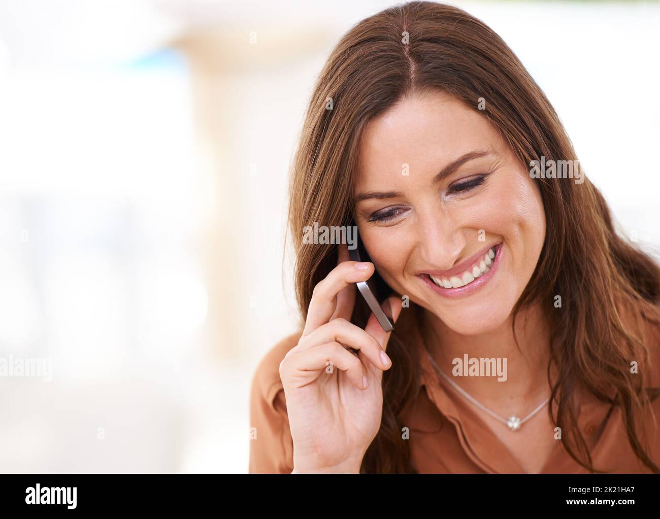 So glücklich, von ihrer Freundin zu hören. Eine attraktive Frau, die auf einem Handy spricht. Stockfoto