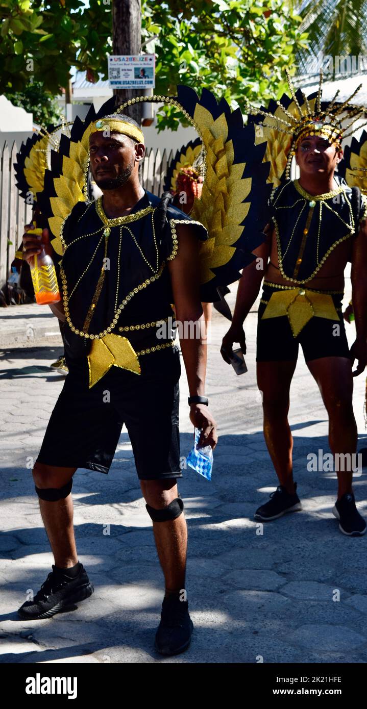 Ein belizischer Mann, der ein glänzendes, geflügeltes, schwarz-gelbes Kostüm trägt, tanzt in der Parade zum Karneval 2022 in San Pedro, Belize. Stockfoto