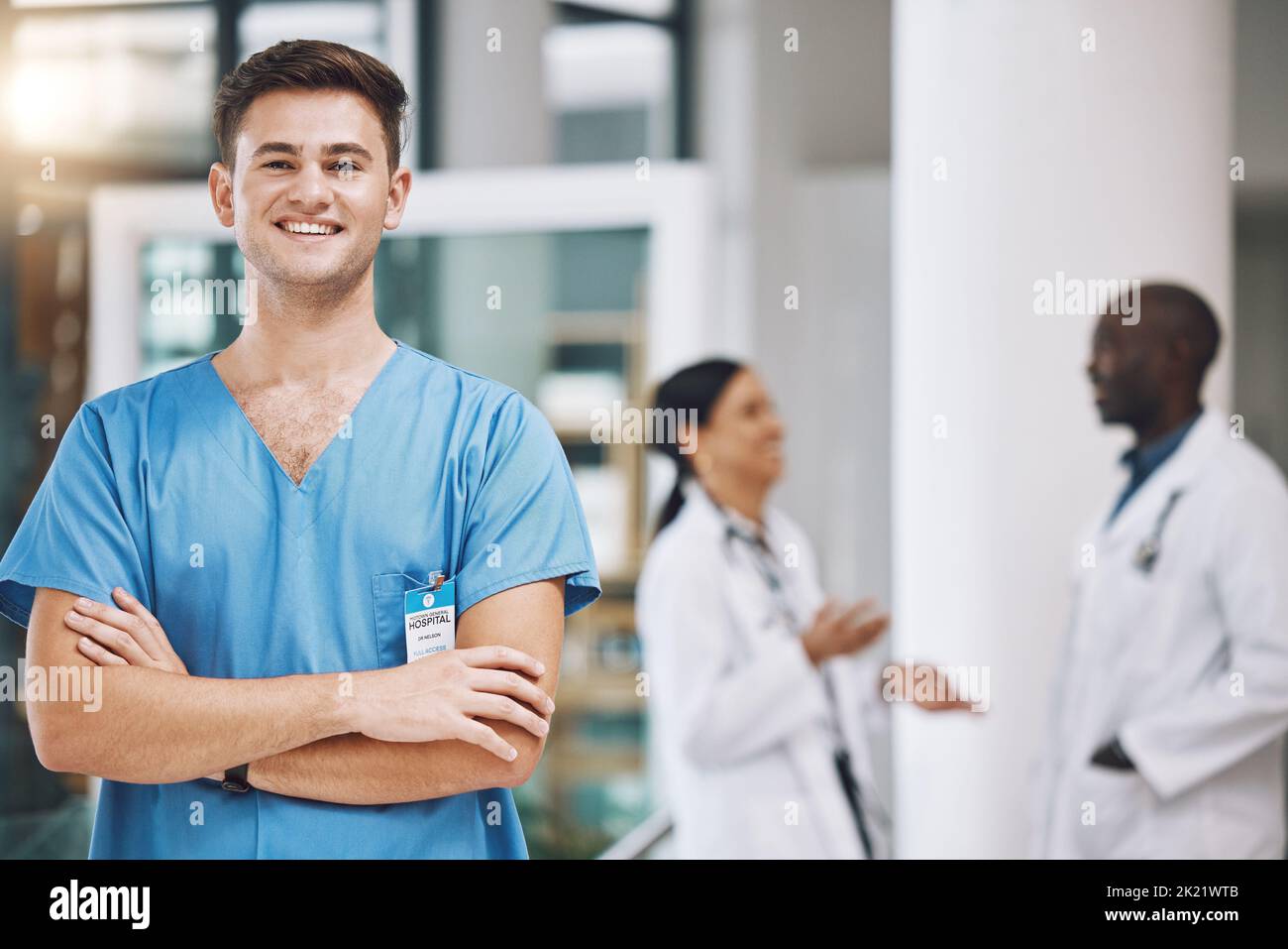 Porträt eines Krankenpflegers mit seinem Team im Hintergrund im Krankenhaus. Glücklich, lächelnd und zuversichtlich Krankenschwester mit Ärzten in Medizin, Gesundheit und Stockfoto