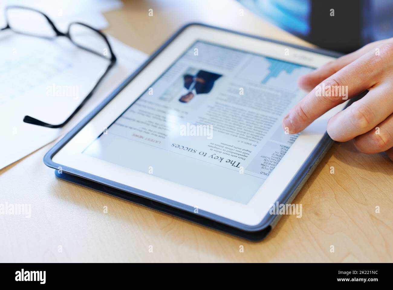 Die Geschäftszeitschriften online durchlesen. Nahaufnahme eines Geschäftsmannes, der an einem digitalen Tablet arbeitet. Stockfoto
