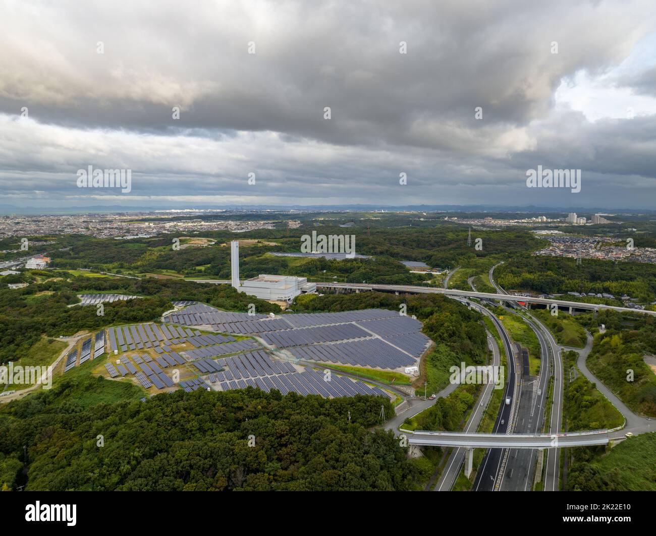 Luftaufnahme von dunklen Sturmwolken über Paneelen auf einem kleinen Solarpark neben der Autobahn Stockfoto