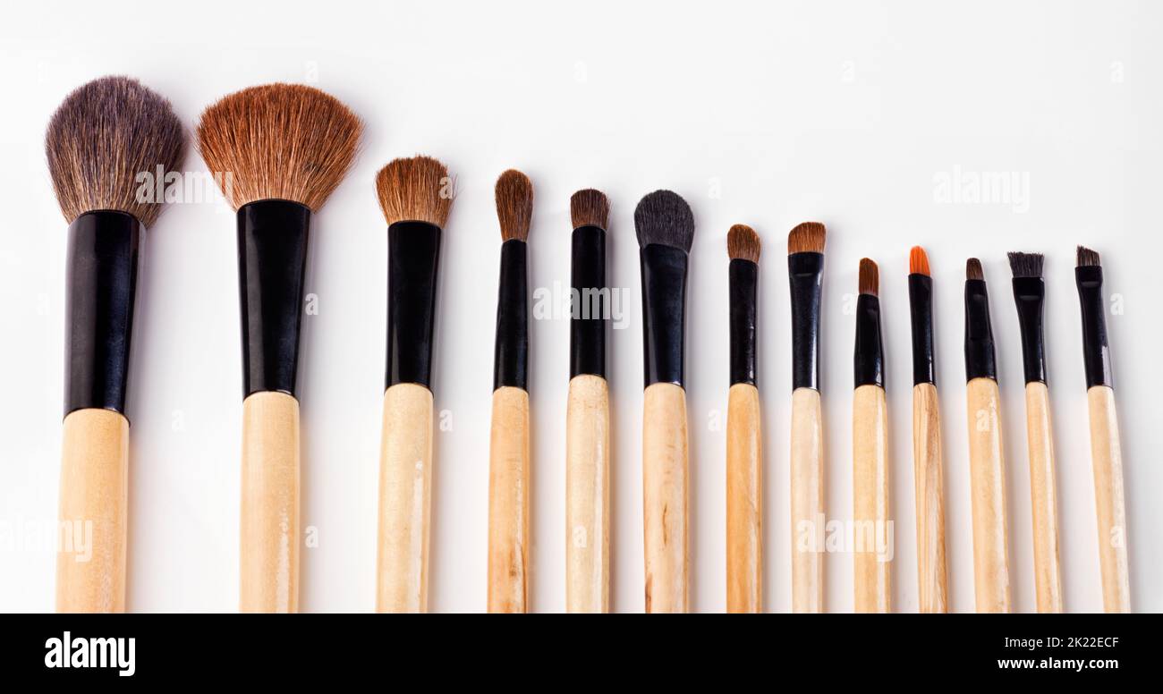 Die Werkzeuge des Make-up-Handels. Eine Reihe von Make-up-Bürsten vor weißem Hintergrund verteilt. Stockfoto