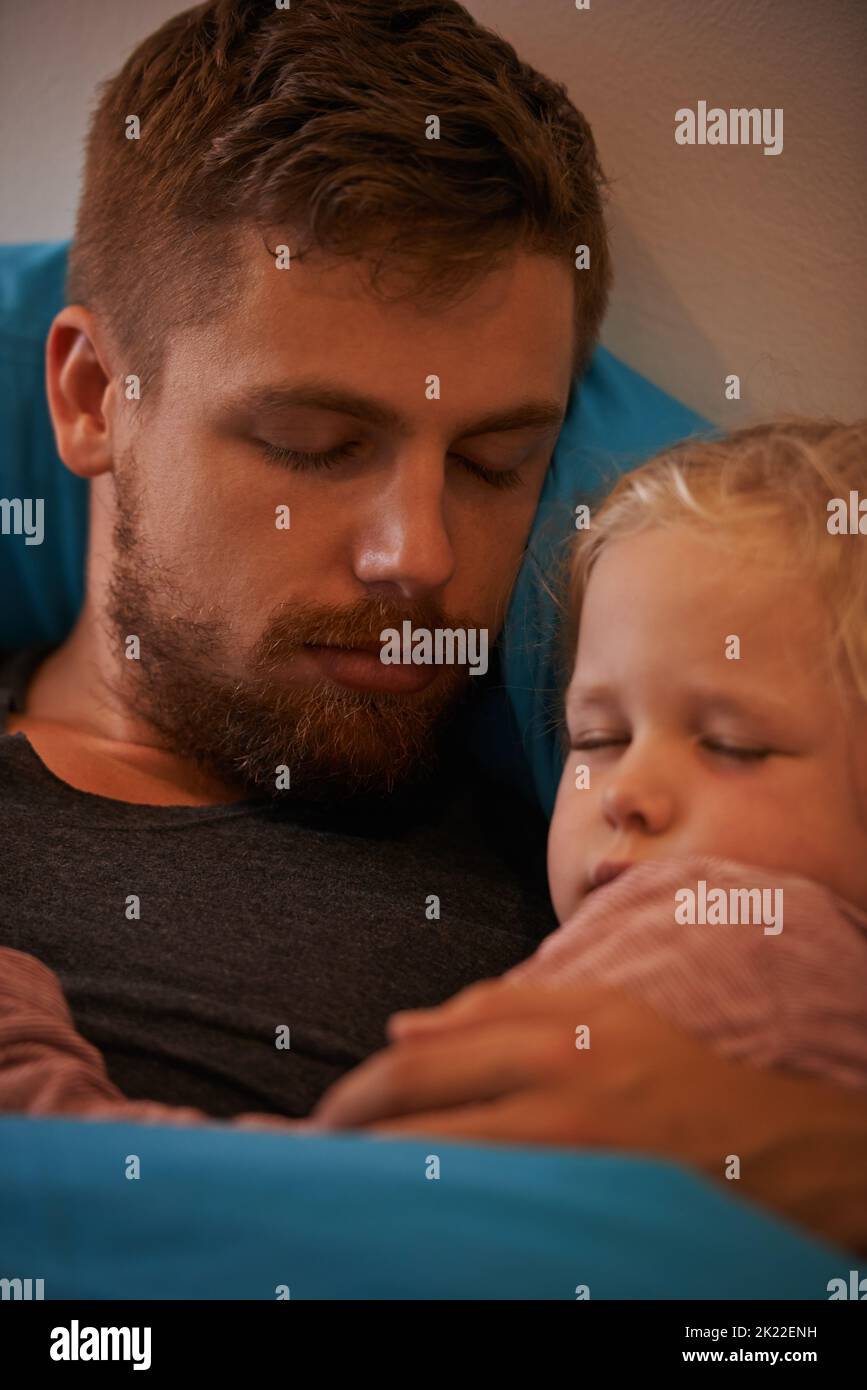 Sicher in ihren Armen. Ein kleines Mädchen, das im Bett in den Armen