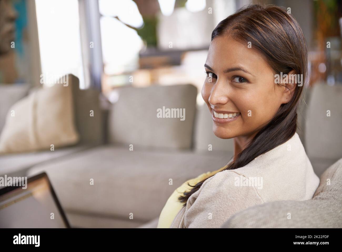 Ich sende dir eine Freundschaftsanfrage. Porträt einer attraktiven jungen Frau, die ihren Laptop benutzt, während sie auf der Couch sitzt. Stockfoto