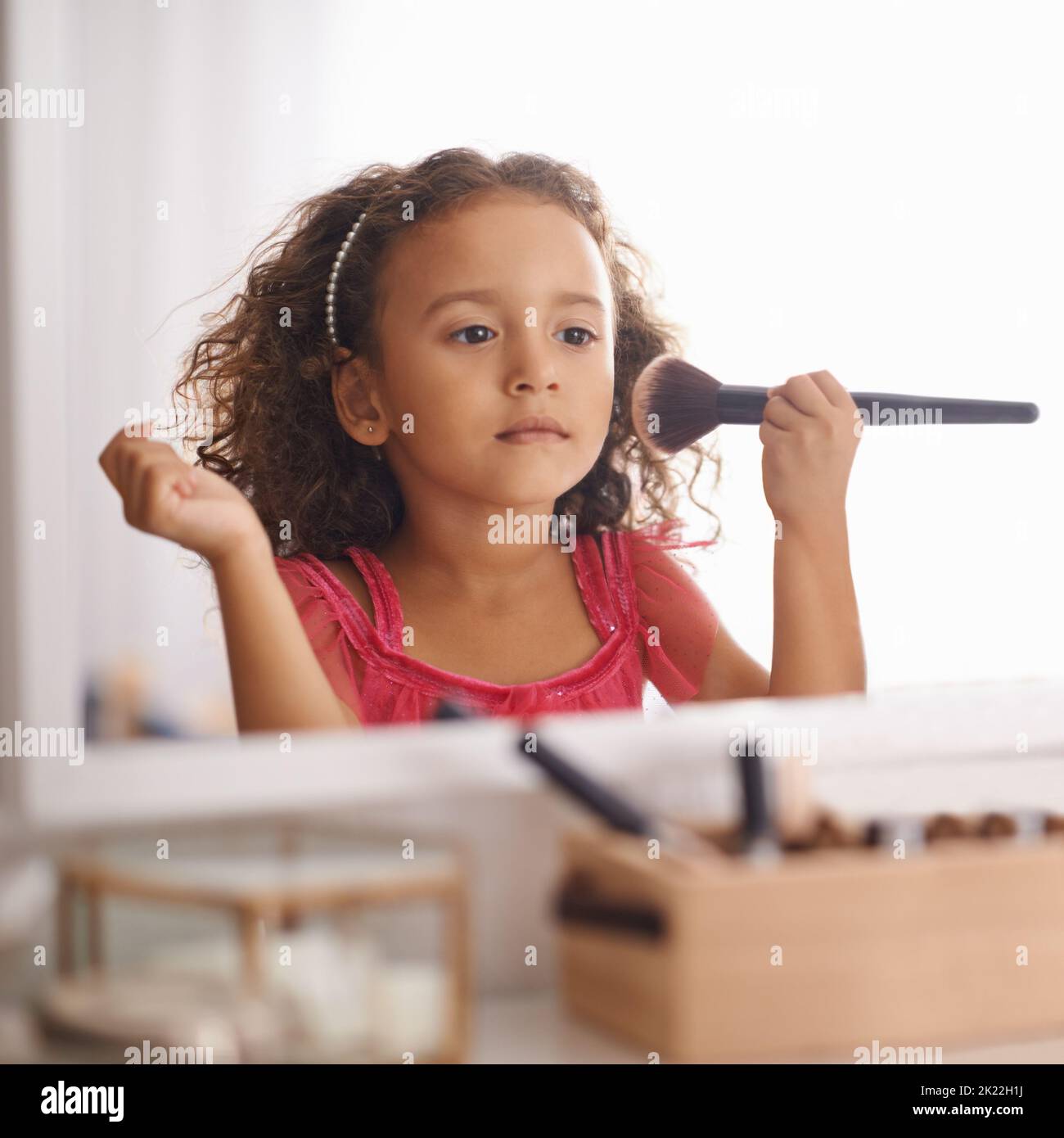 Im gonna Look just like my Mama. A Little girl apping Blusher in den Spiegel. Stockfoto