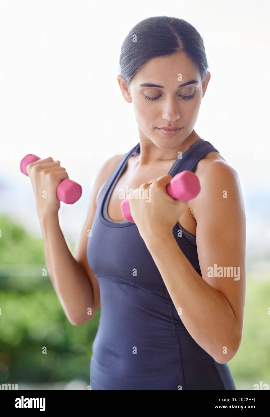 Perfektioniert ihre Gewichtheben-Technik. Eine junge Frau arbeitet mit Gewichten. Stockfoto