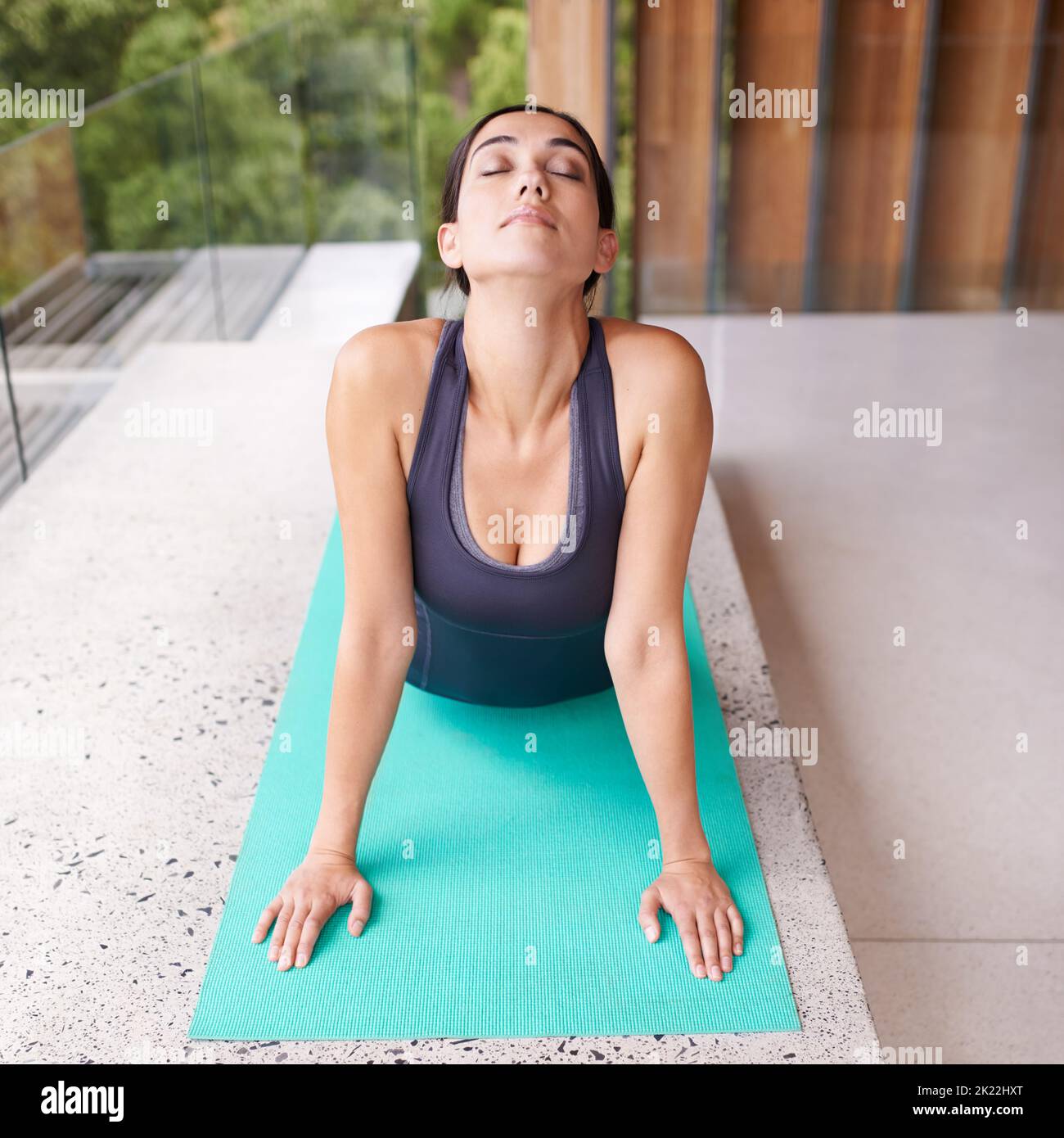 Yoga verlangsamt dich und versetzt dich in das Jetzt. Eine junge Frau, die Yoga macht, dehnt sich aus. Stockfoto