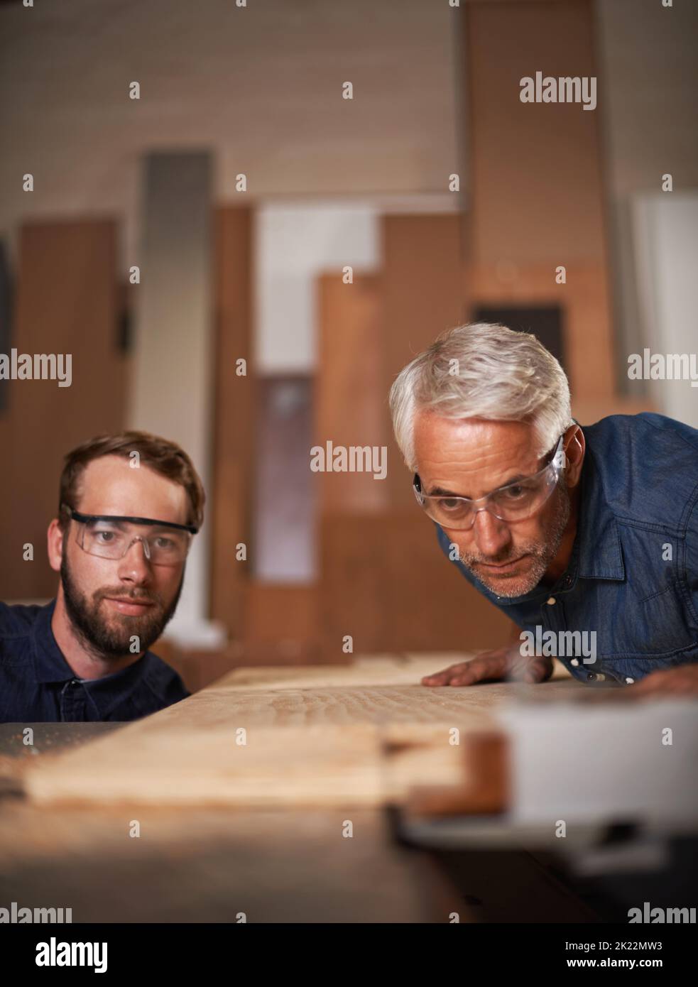 Ein Vater und ein Sohn arbeiten in einer Werkstatt zusammen. Stockfoto