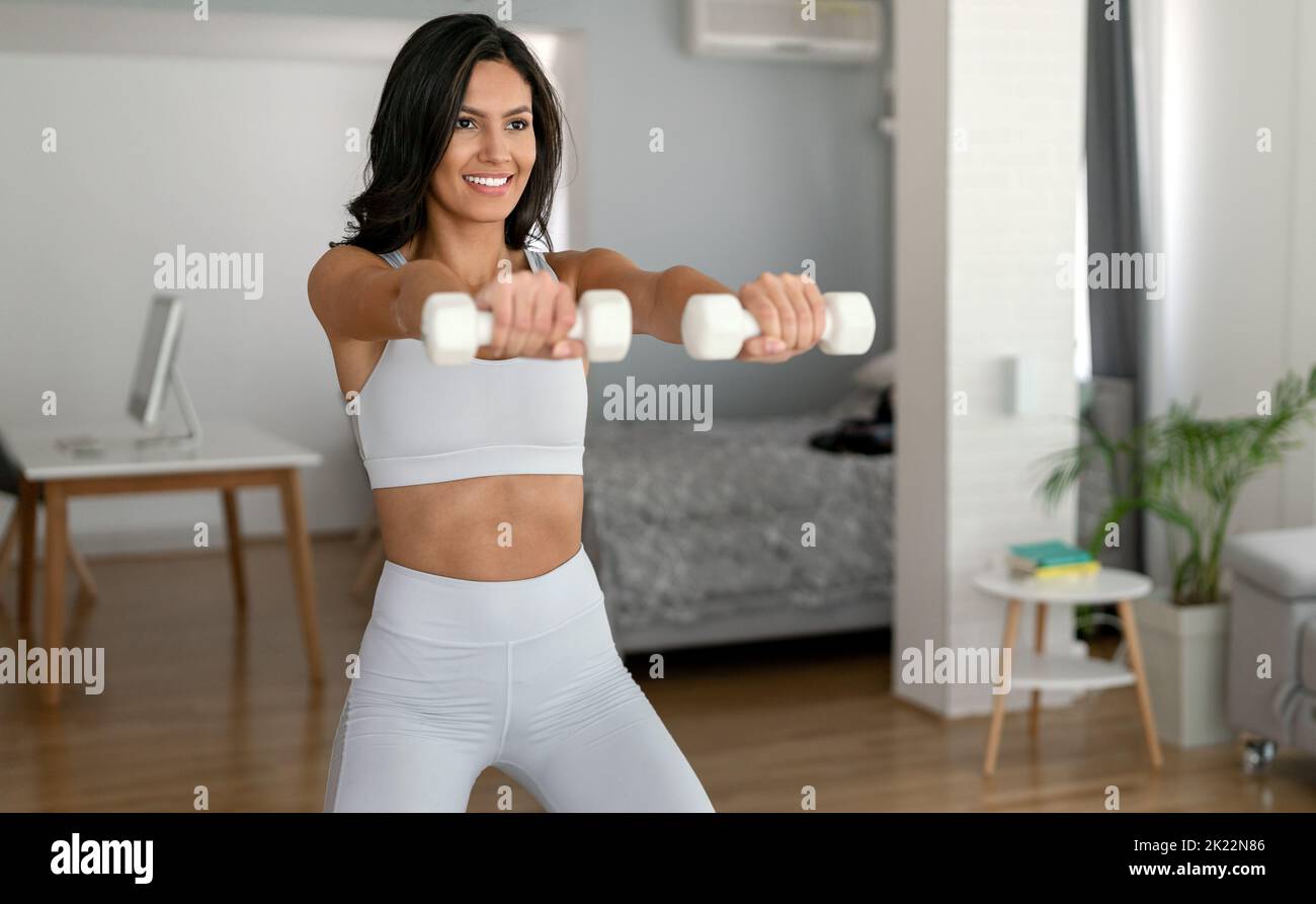 Schöne junge fit Frau macht Übungen zu Hause. Fitness, gesunder Lebensstil, Sportkonzept Stockfoto