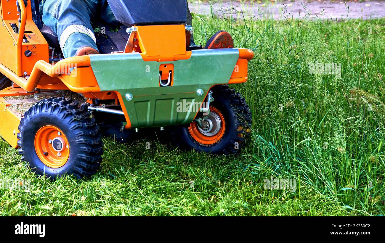 Professionelles Rasenmähen auf Rasenflächen mit einem Mini-Traktor-Rasenmäher. Stockfoto