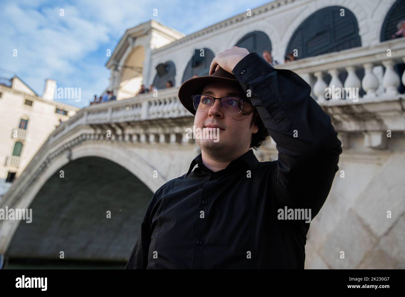 Porträt eines Touristen in Venedig vor der Rialtobrücke zur Seite, Foto mit Copyspace auf der linken Seite Stockfoto