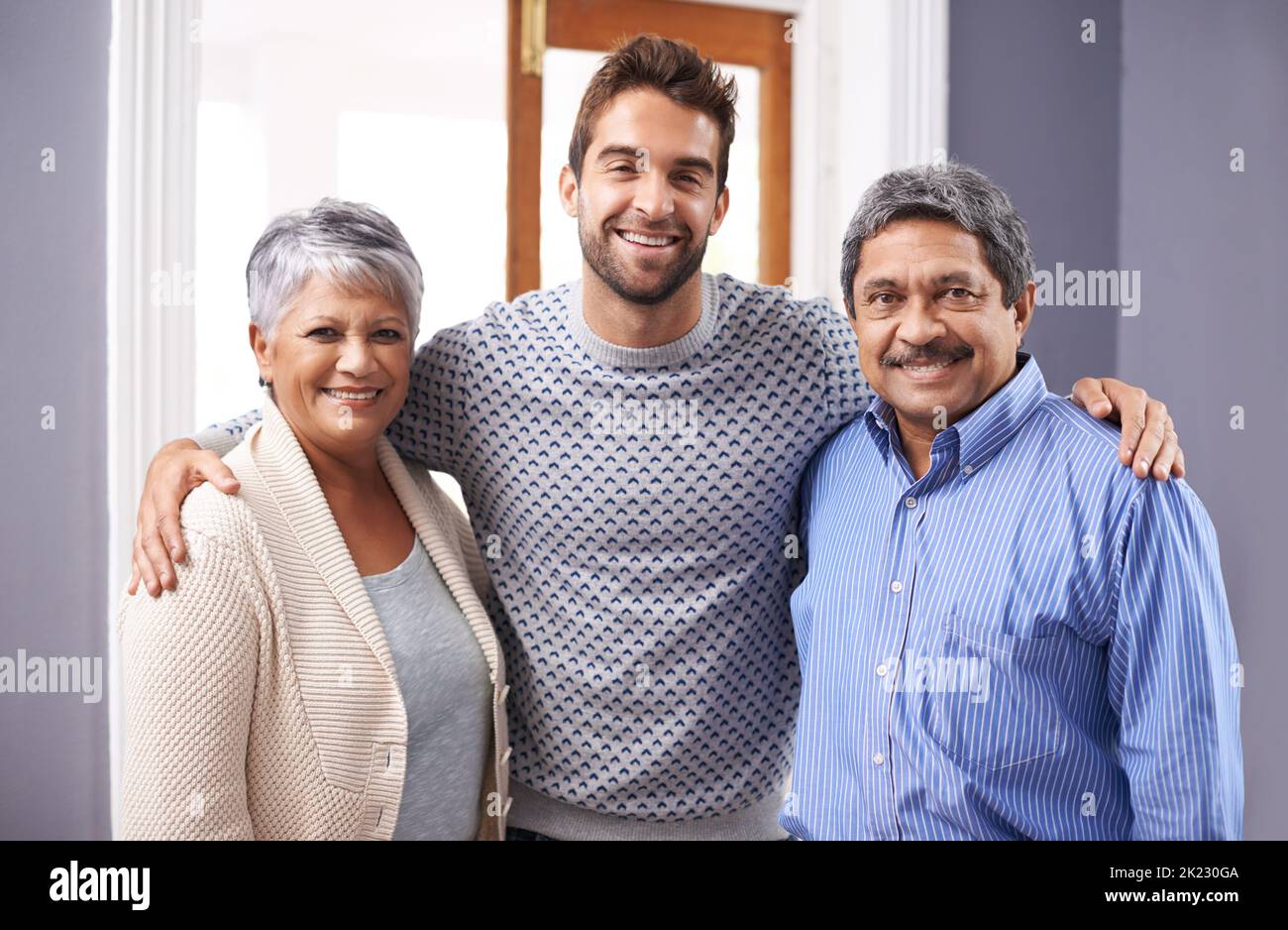 Es ist meine Pflicht, mich um sie zu halten. Porträt eines älteren Ehepaars, das mit seinem erwachsenen Sohn zu Hause steht. Stockfoto